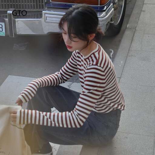 a woman sitting on the ground next to a car.