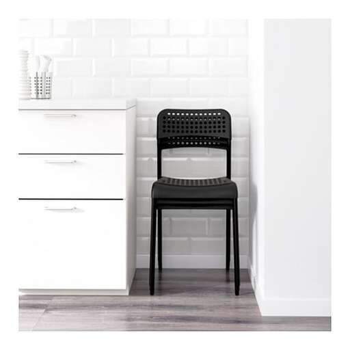 a black chair sitting in a white kitchen.