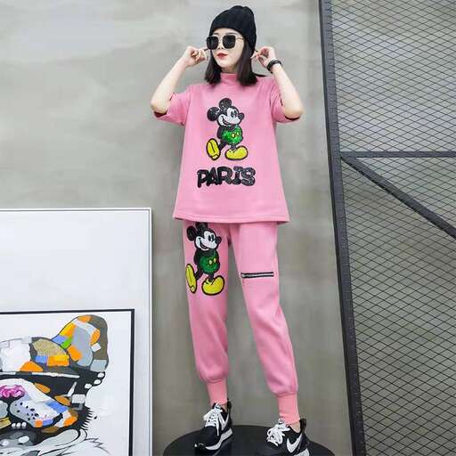 a model poses in a pink outfit.