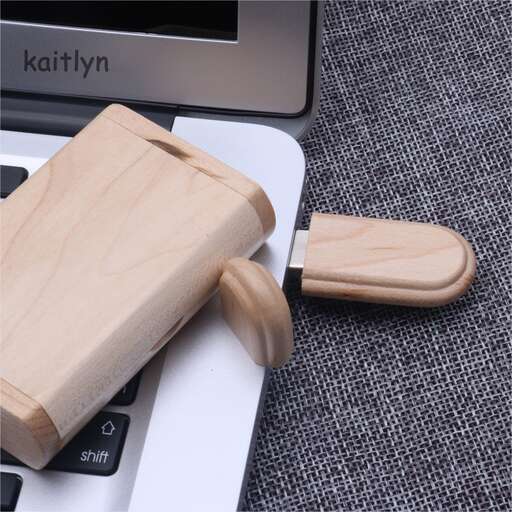 a wooden knife laying on top of a laptop.