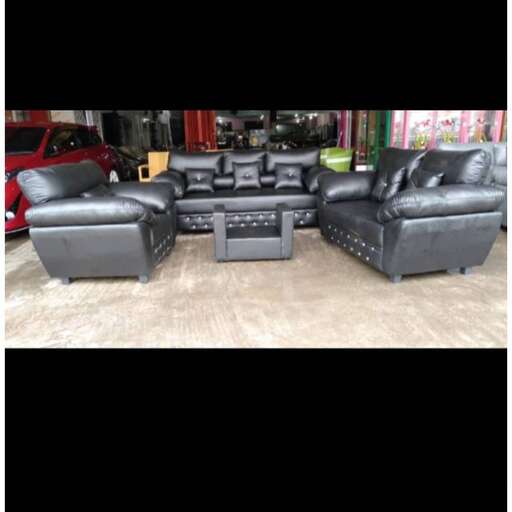a set of black leather couches in a living room.