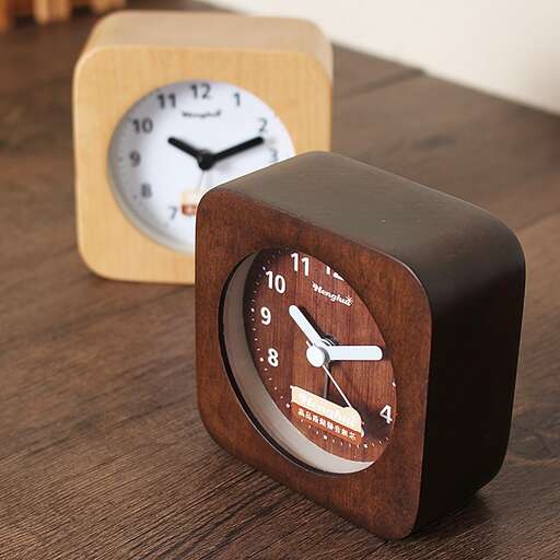 a wooden clock sitting on top of a wooden table.