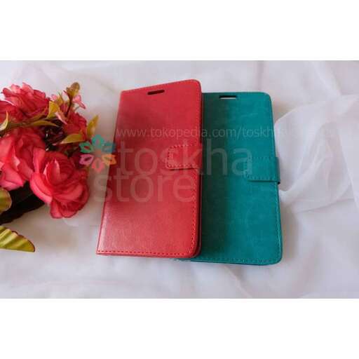a red and green notebook and a red rose in a red case.