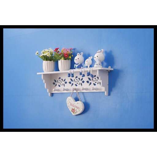 a white shelf with blue and white flowers and a vase.