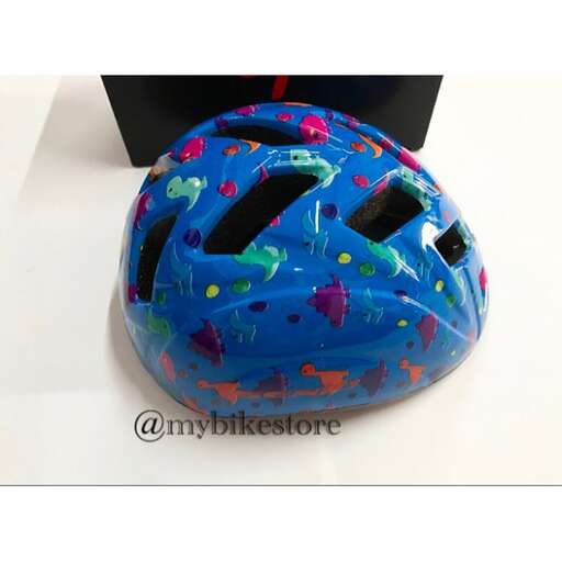a bike helmet sitting on a table with a black box in the background.