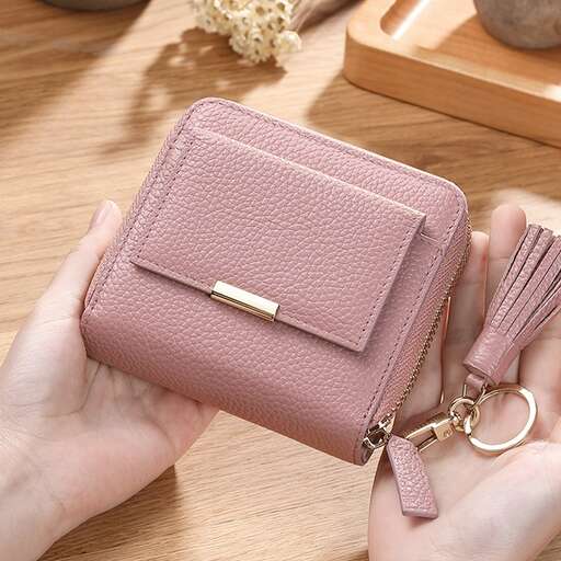 a woman holding a wallet on a table.