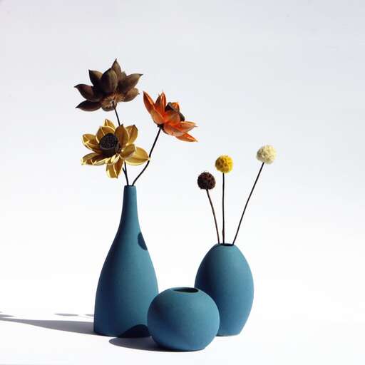three blue vases with flowers in them