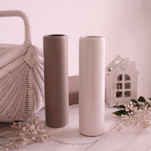 a white table topped with two vases and a house.