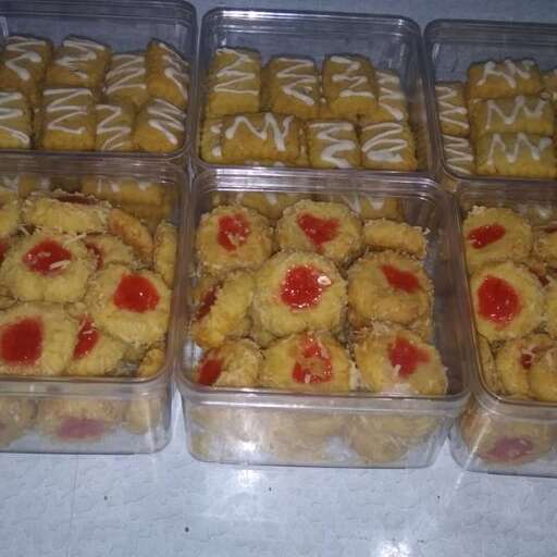 a table topped with containers of food with a bunch of cookies.