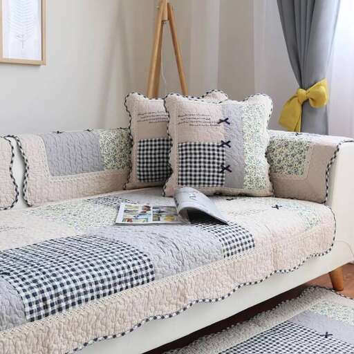 a couch with a blanket on it in a living room.