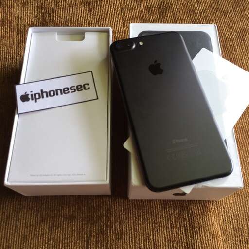 a black iphone and a white box on a table.
