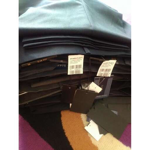 a pile of black and brown bags with tags.