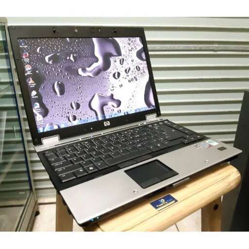 a laptop computer sitting on a desk in a room.