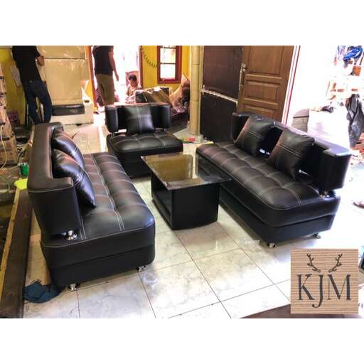 a living room with two black leather couches.
