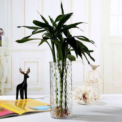 a vase with a plant and a small animal figurine.