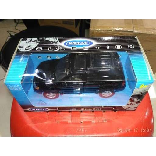 a toy car in a box on a red table.