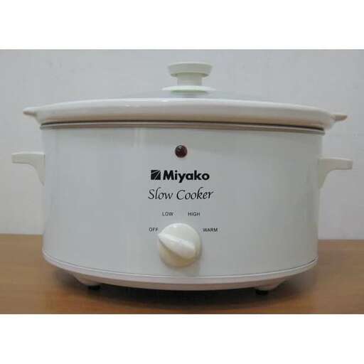 a crock pot on a table with a lid.