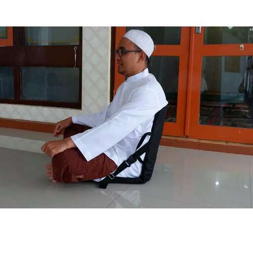 a man in a white robe sitting on a chair.