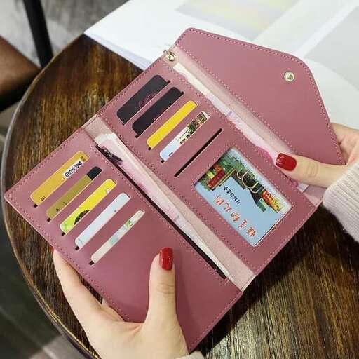 a hand holding a wallet with a picture of a woman holding a pencil.