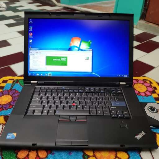 a laptop computer sitting on top of a colorful rug.