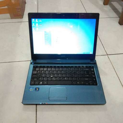 a laptop computer sitting on top of a tile floor.