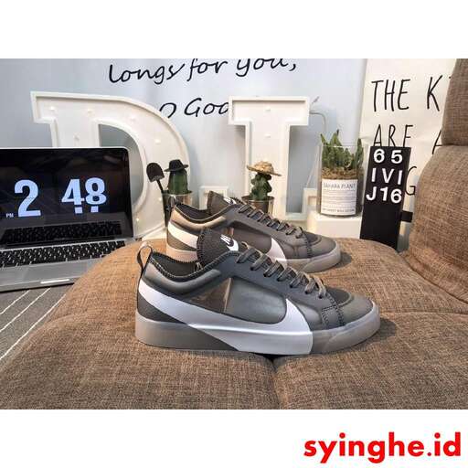 a pair of sneakers sitting on a couch next to a laptop.