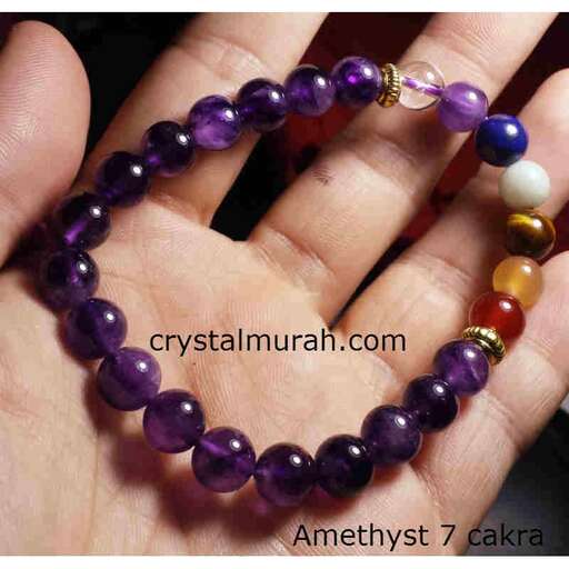 a bracelet of purple glass beads with white and purple glass beads in the middle.
