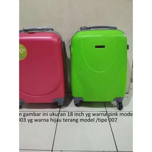 a green suitcase with a pink suitcase on the ground.