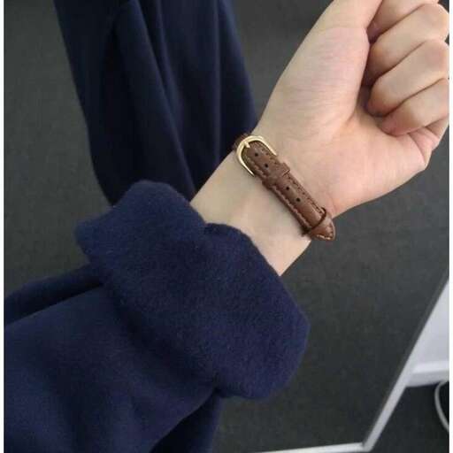 a watch with a brown leather band on it.