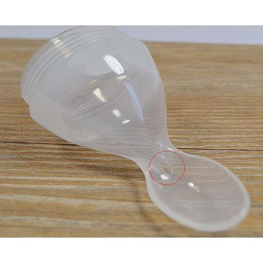 a plastic wine glass with a red spot on the bottom.