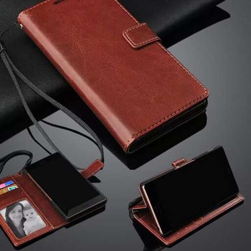 a brown leather wallet with a cell phone in it.