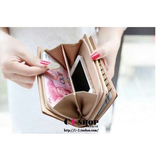 a woman holding a wallet with money in it.