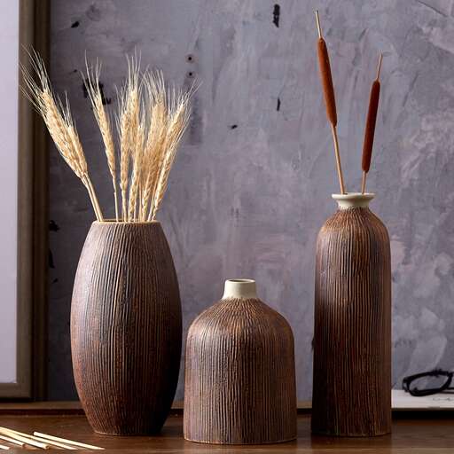 three vases with straws in them are arranged in a row.