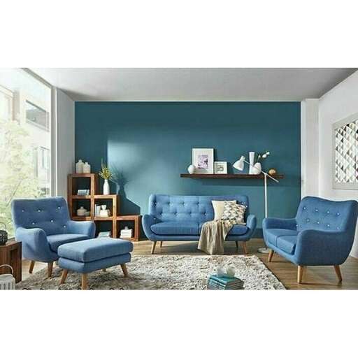 a living room with blue walls and a blue chair.