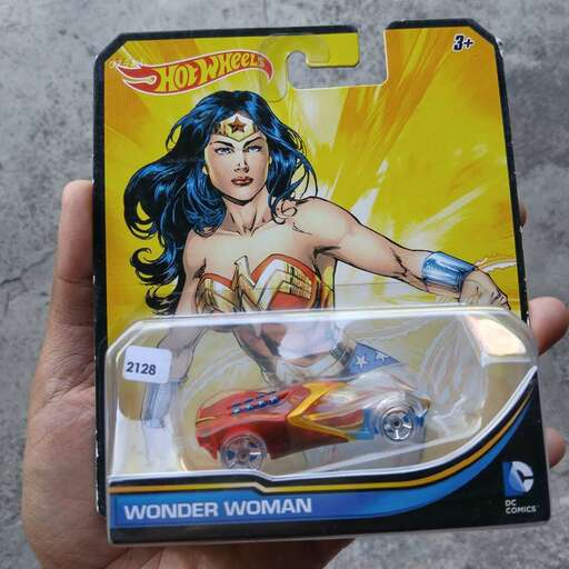 a hand holding a toy of comic book character