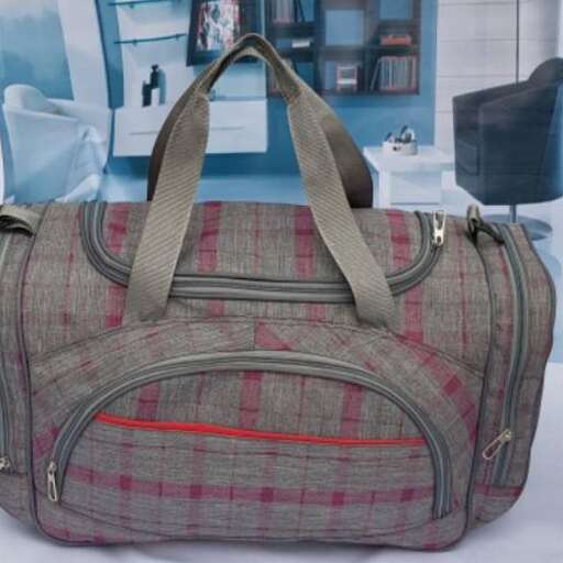 a bag with a red stripe on it sitting on a bed.