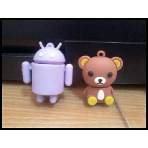 two cute little bears in front of a computer monitor.