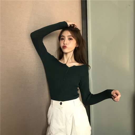 a model poses in a black blouse and white pants.