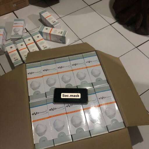 a box of money on the floor with a cell phone in it.