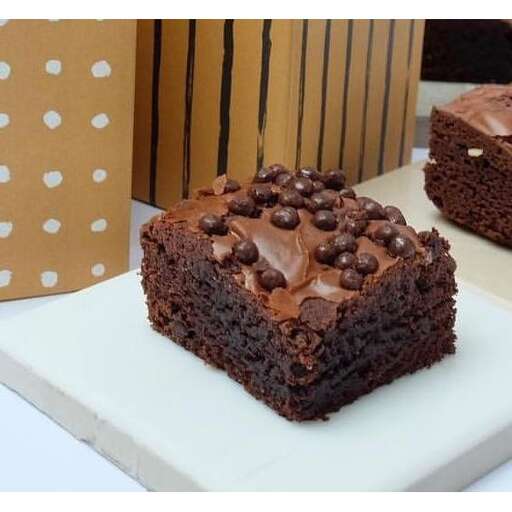 a square piece of chocolate cake on a white plate.