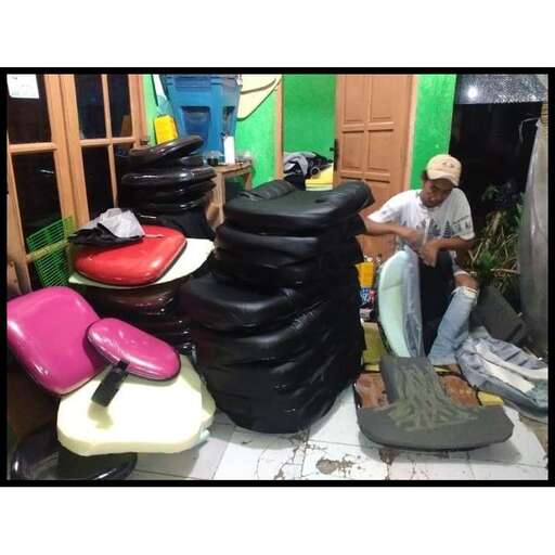 a man sitting on a floor next to a pile of tires.