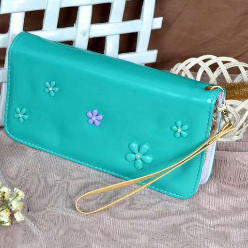 a beautiful turquoise handbag with flowers in the center.