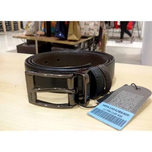 a black leather belt sitting on a table.