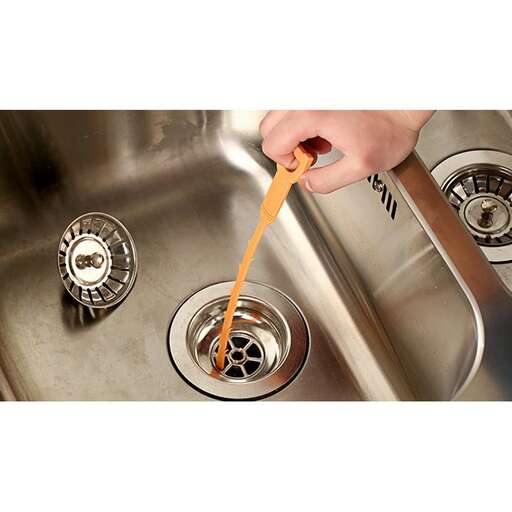 a person holding a spoon over a sink.