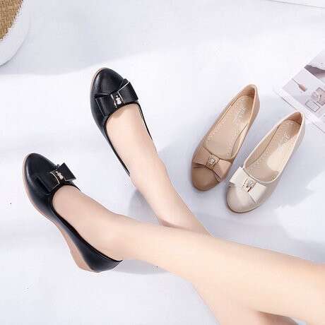 a woman's legs with a pair of black shoes.