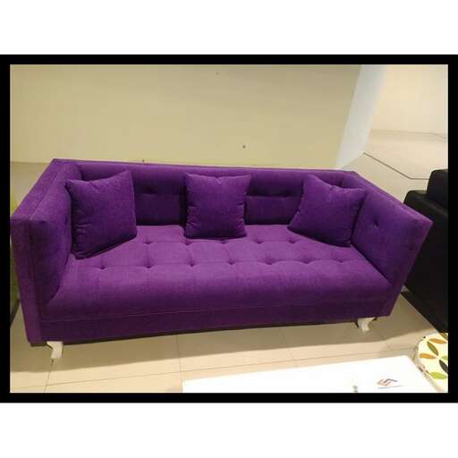 a purple couch sitting on a table in a room.