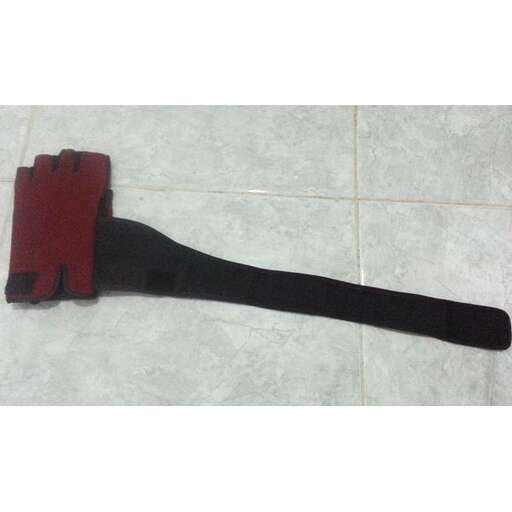 a black strap with a red handle on the floor.
