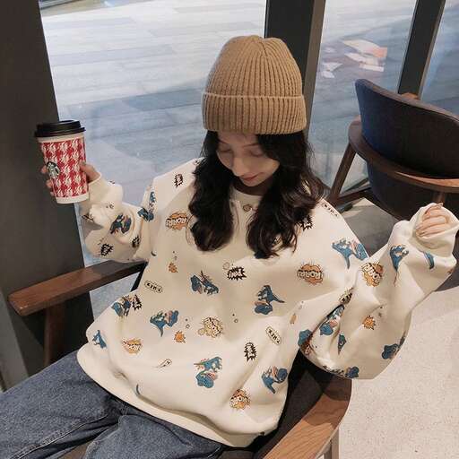 a girl sitting on a chair holding a cup.