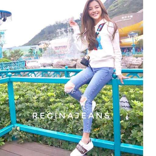 person is all smiles in a white sweater and jeans