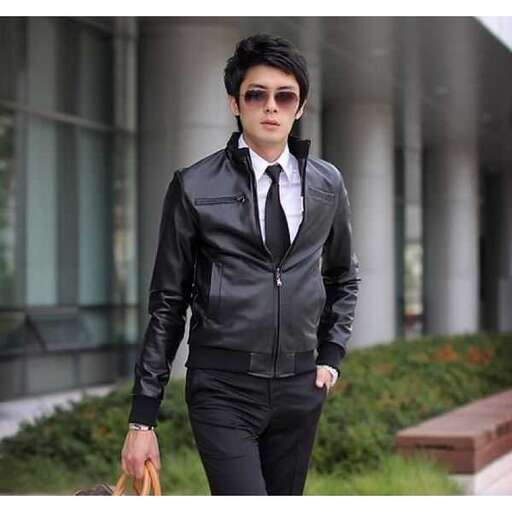 a man in a leather jacket and tie is walking.